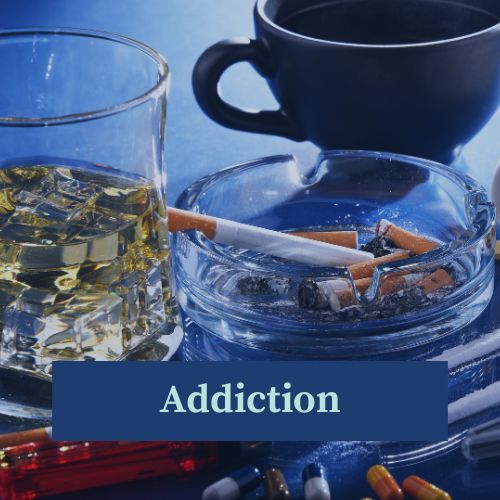 A glass of whisky, a coffee cup, an ashtray with cigarettes and stubs, and some pills and powders showing the things people are typically addicted to